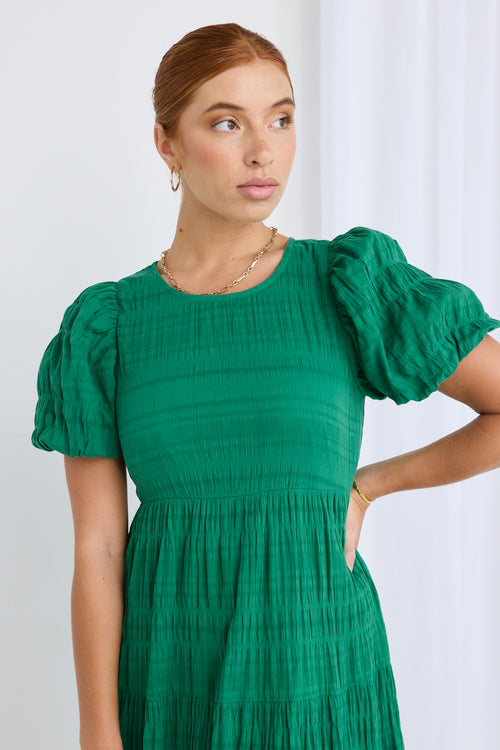 model wears a green maxi dress