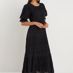 model wears a black maxi dress with black sandals