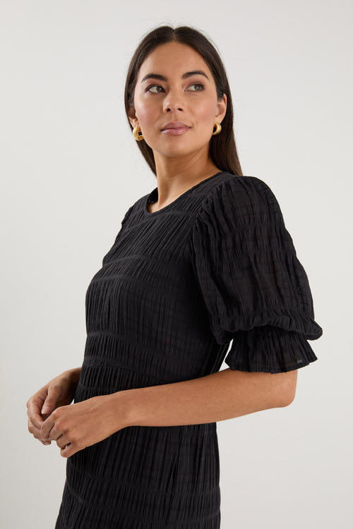 model wears a black maxi dress with black sandals