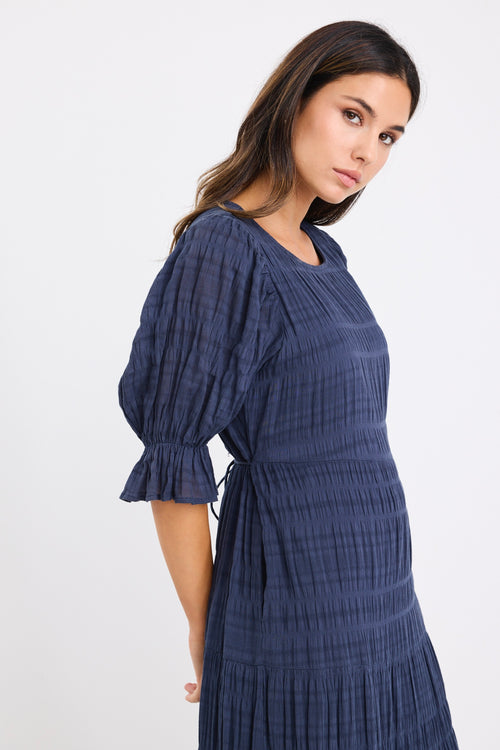 model wears a dark blue maxi dress