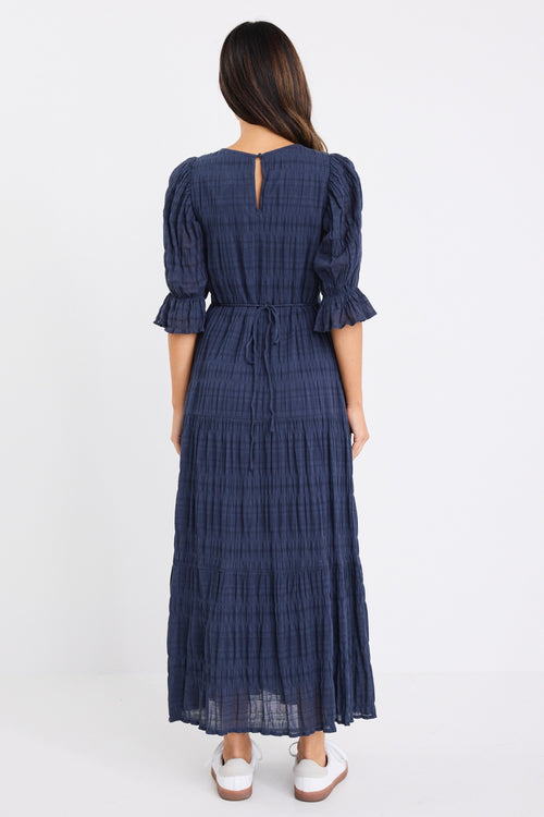 model wears a dark blue maxi dress