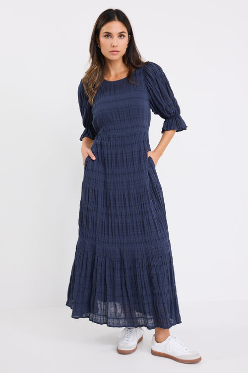 model wears a dark blue maxi dress