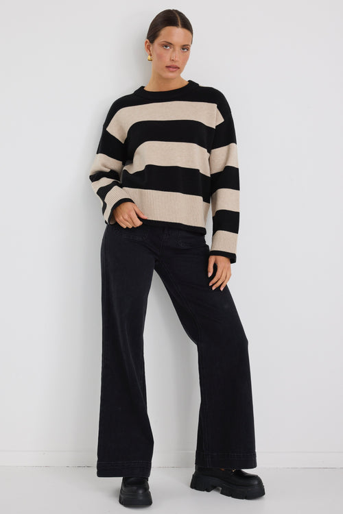 Model wears a black and beige stripe jumper