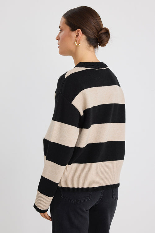 Model wears a black and beige stripe jumper