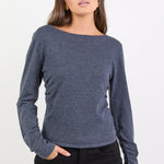 Woman wearing a charcoal top against a white background