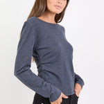 Woman wearing a blue sweater and black pants on a white background