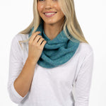 Woman wearing a teal scarf around her neck on a white background