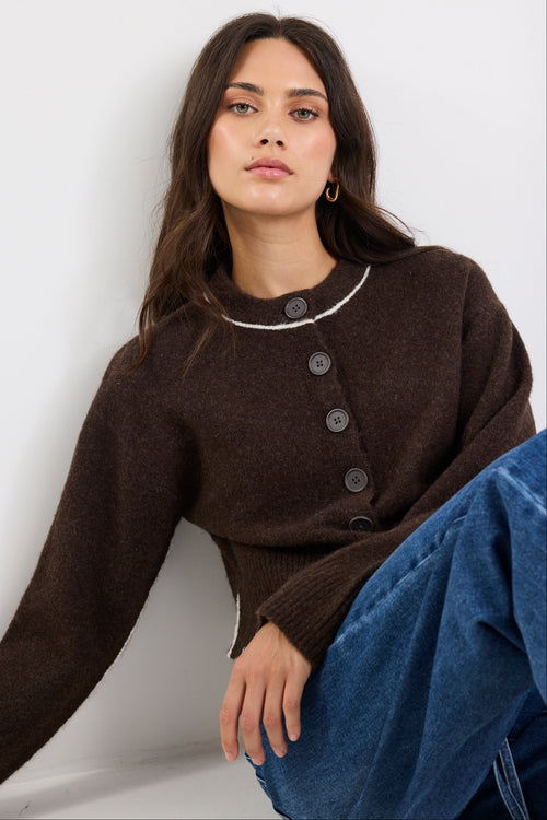 Woman wearing a brown button-up top with a white background