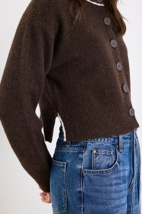 Brown button-up sweater worn by a person with a white background