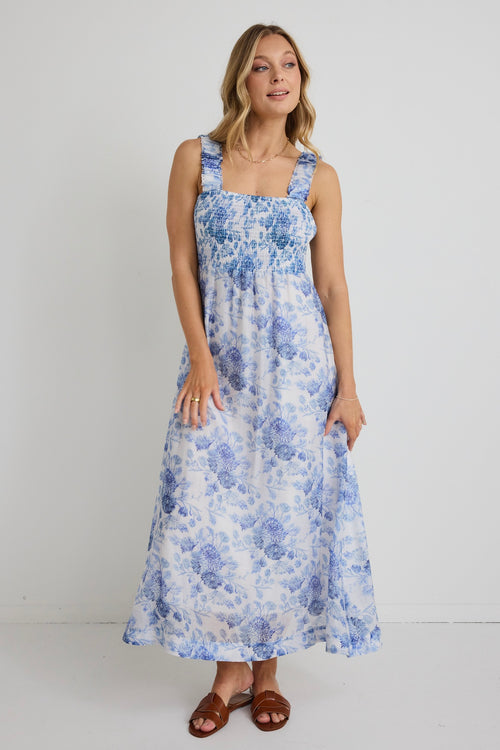 model wears blue floral maxi dress and brown sandals