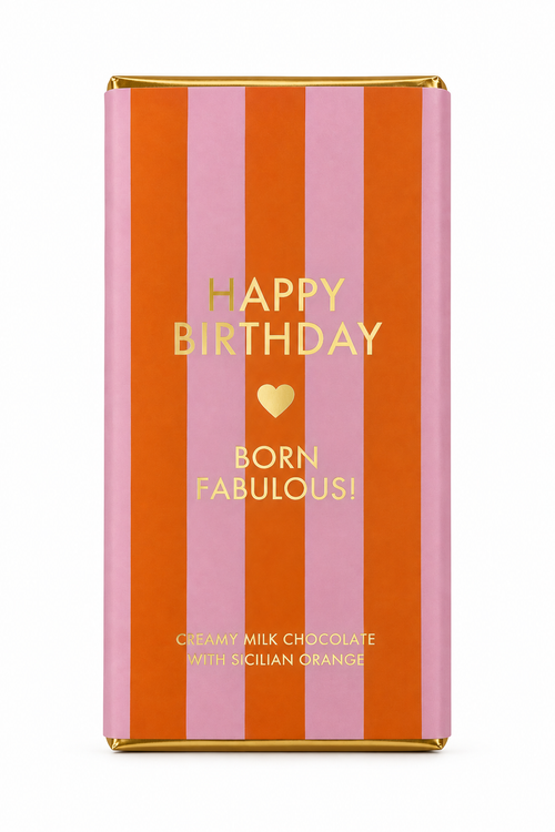 A wrapped chocolate bar in a pink and orange striped wrapper with gold foil text reading 'HAPPY BIRTHDAY BORN FABULOUS!' on a white background.