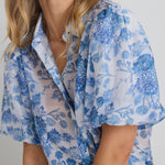 model wears a blue floral shirt 