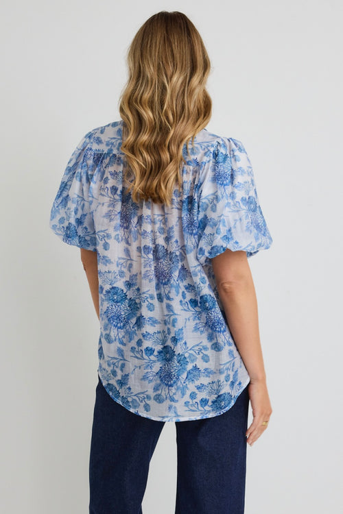 model wears a blue floral shirt 