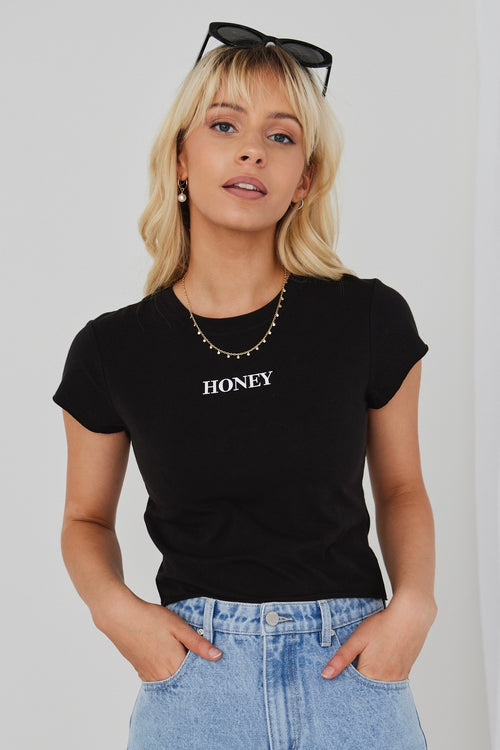 model wears black crop top and blue jeans