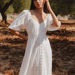 model wears a white midi dress