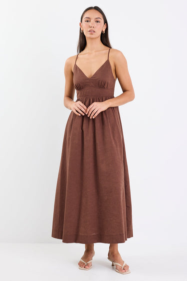 Model wearing a chocolate brown strappy midi dress with a relaxed fit and natural linen-cotton blend.