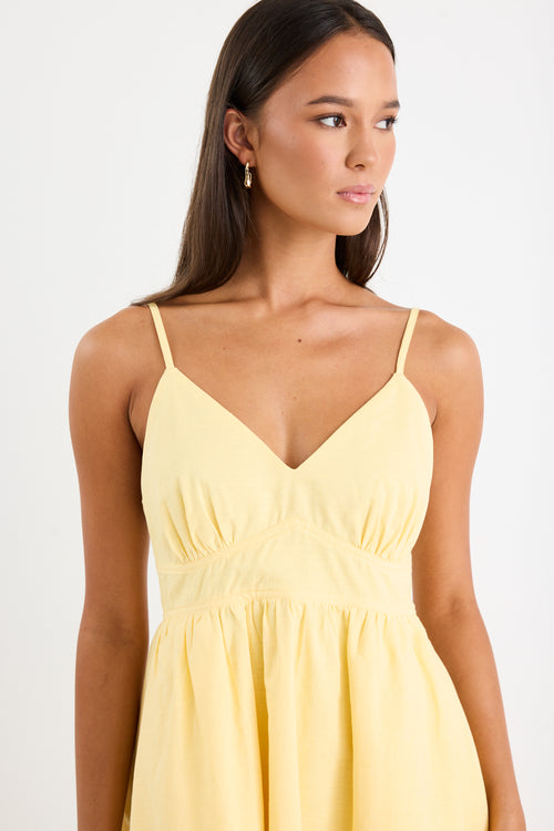 Woman wears a yellow mini dress with v-neck