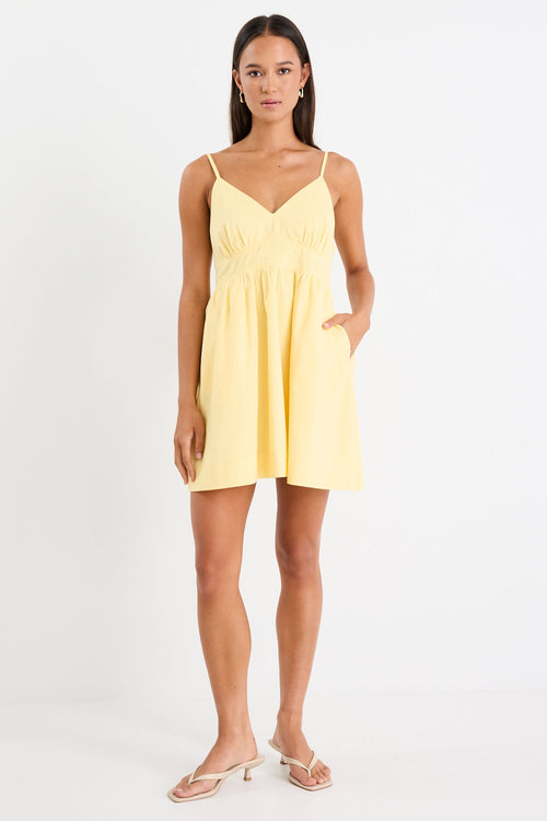 Woman wears a yellow mini dress with v-neck