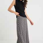 Woman wearing a black sleeveless top and checkered skirt on a white background