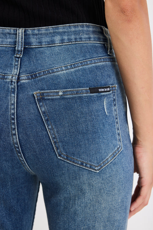 Close-up of blue jeans with a brand label on the pocket against a white 
background
@col_pattern