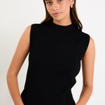 Woman wearing a black sleeveless ribbed top against a white background