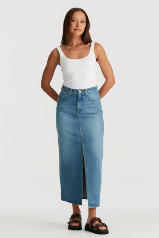 model wears blue denim maxi skirt and white tank top