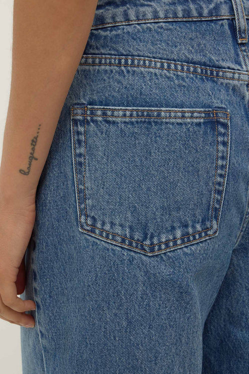Close-up of blue jeans with a pocket on a plain background