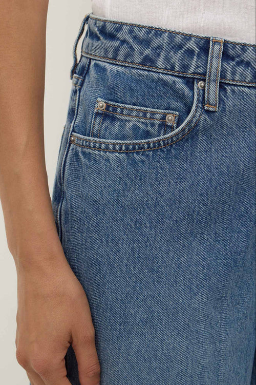 Close-up of blue jeans with a plain background