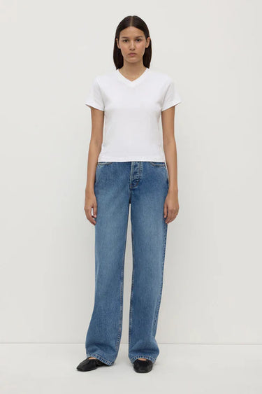 Person wearing a white t-shirt and blue jeans on a white background