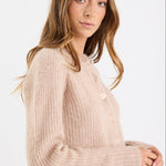 Woman wearing a beige sweater on a white background