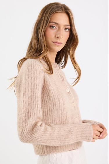 Woman wearing a beige sweater on a white background