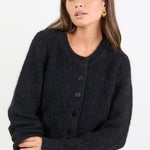 Woman wearing a black cardigan on a white background