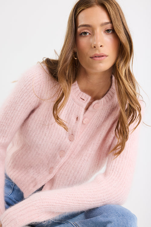 Woman wearing a pink sweater against a white background