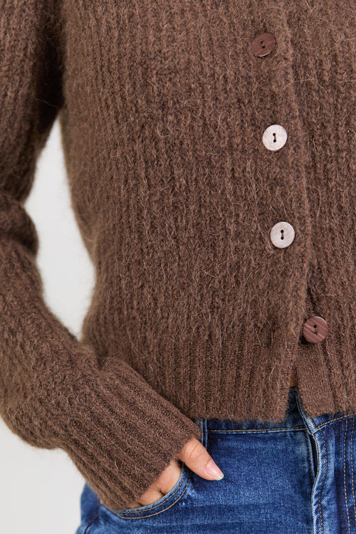 Brown knitted cardigan worn by a person with a white background