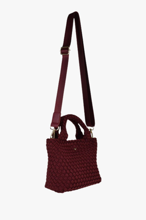 Cherry red woven mini tote bag with top handles and a soft textured finish