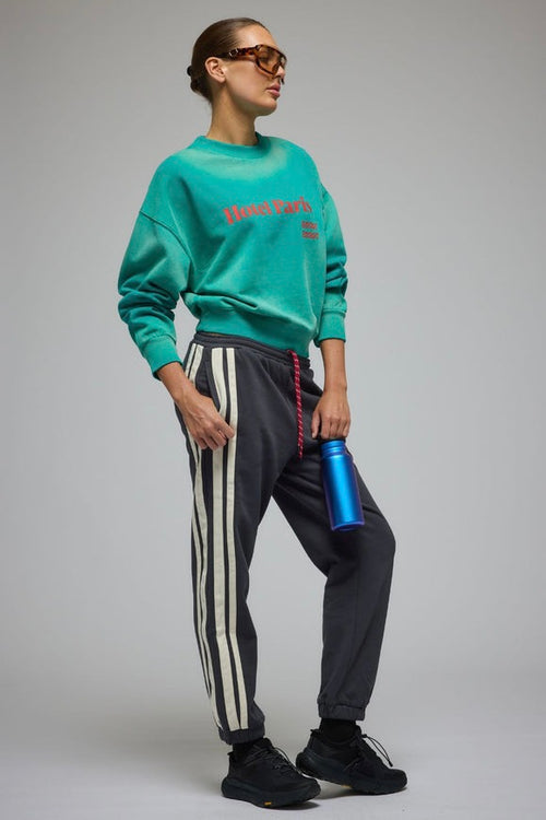 Woman wearing an oversized ocean green crew sweatshirt with 