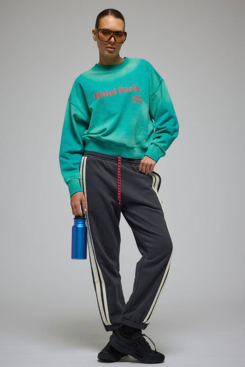 Woman wearing an oversized ocean green crew sweatshirt with 