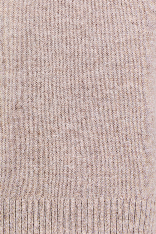 Close-up of a beige knitted fabric with a ribbed edge