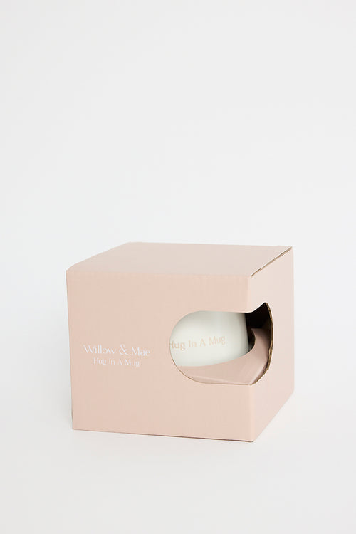 Natural ceramic mug packaged inside a soft beige cardboard box with a cut-out window showing the words ‘Hug In A Mug’ on the mug, photographed on a white background
