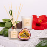 Candle and diffuser set with 'Island Bloom' branding, surrounded by tropical elements on a white background.