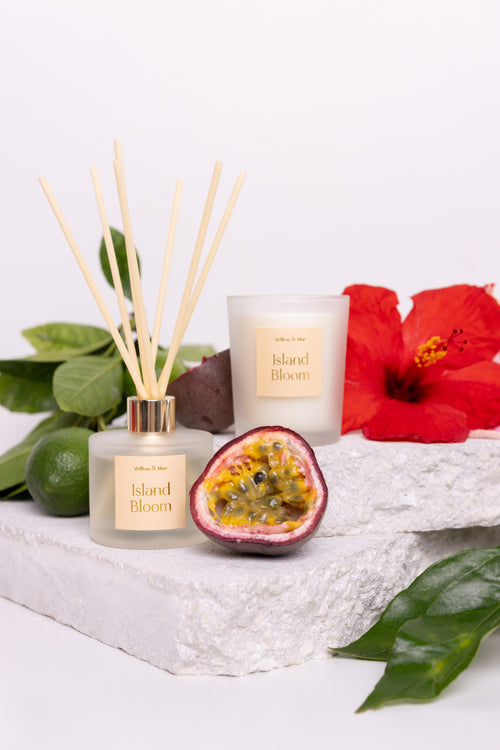 Candle and diffuser set with 'Island Bloom' branding, surrounded by tropical elements on a white background.