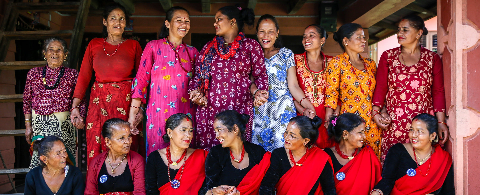 Group of women in colorful traditional attire posing together.