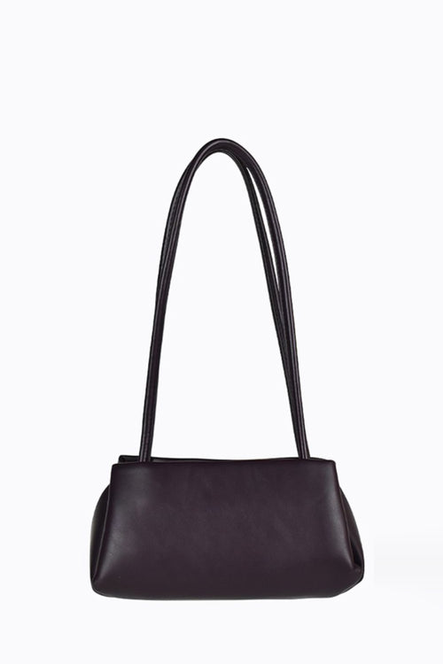 A dark chocolate leather shoulder bag with a single long strap and a small gold logo on the front, set against a plain white background.