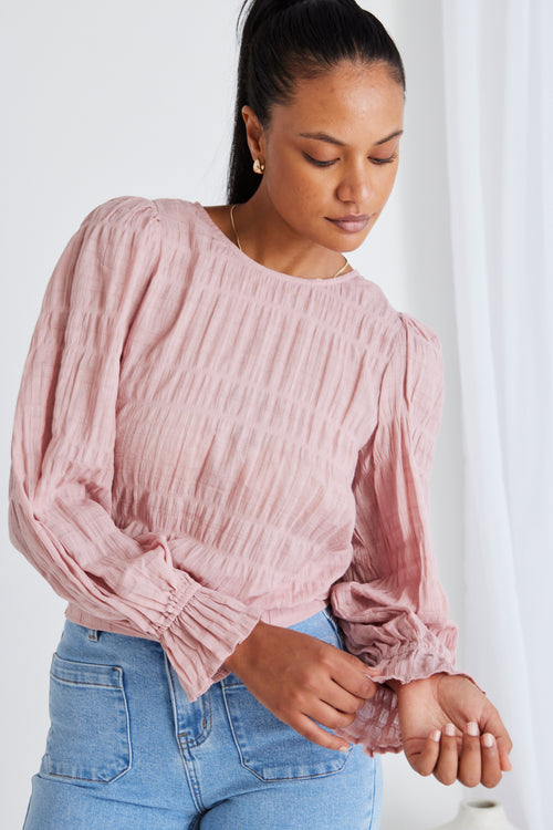 model wears a pink blouse