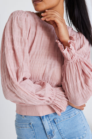 model wears a pink blouse