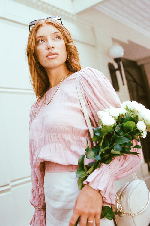 model wears a pink blouse