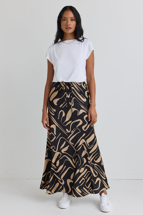 model wears a black and beige pattern maxi skirt