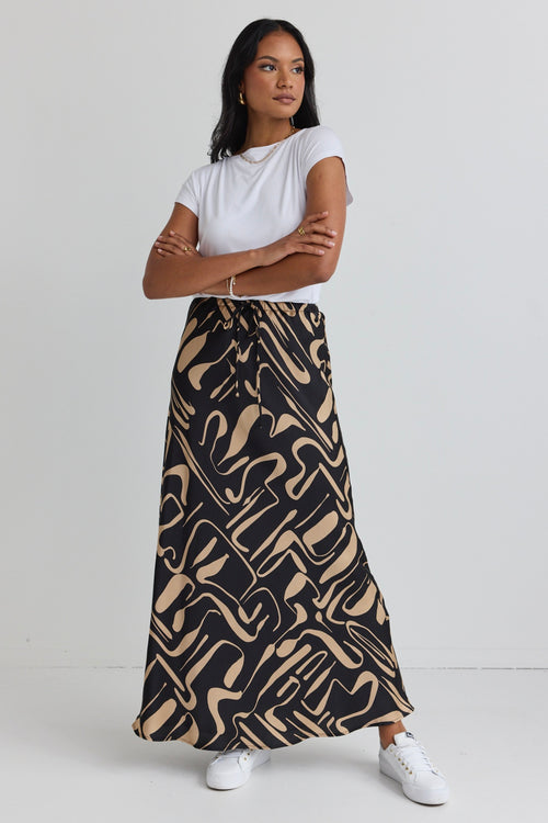 model wears a black and beige pattern maxi skirt