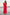 A woman wearing a bright red maxi dress with ruffled short sleeves and a V-neckline stands on a concrete pier with the ocean and cloudy sky in the background.