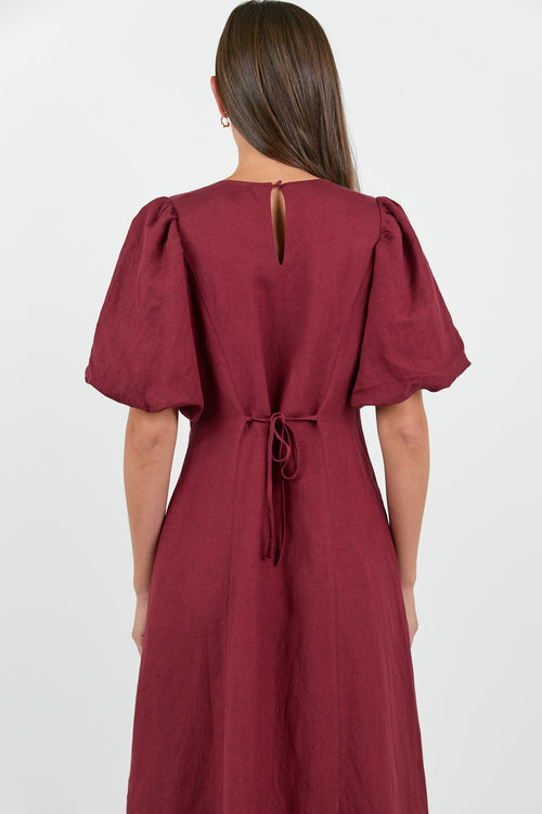 Maroon dress with puff sleeves on a white background